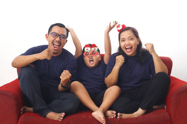 亚洲家庭坐在红色沙发上庆祝圣诞节和新年 因白人背景而被隔离 — 图库照片