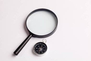 Beyaz zemin üzerinde cetvel ve büyüteç olan klasik pusula üst görünümü