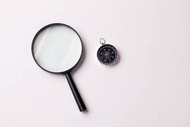 Beyaz zemin üzerinde cetvel ve büyüteç olan klasik pusula üst görünümü