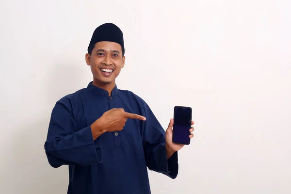 Szczęśliwy Azjata Stojąc Trzymając Wskazując Komórkę Koncepcja Ramadanu — Zdjęcie stockowe