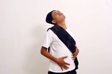 Asyalı adam çok fazla yemek yedikten sonra çok tok hissediyor. Adamın midesi yiyecekle dolu. Beyaz arkaplanda izole