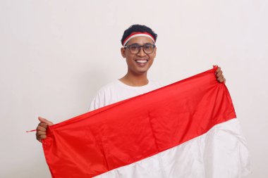 Asyalı adam, elinde Endonezya bayrağı tutarak bağımsızlığını kutluyor.