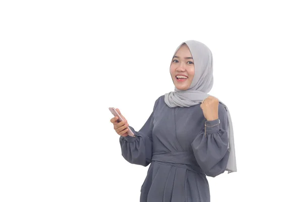 Χαρούμενη Ασιάτισσα Μουσουλμάνα Που Στέκεται Κρατώντας Ένα Κινητό Και Σφίγγοντας — Φωτογραφία Αρχείου