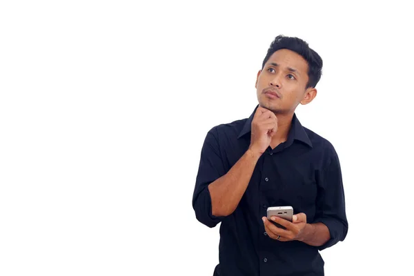 Eftertänksam Asiatisk Man Som Står Och Håller Mobil Isolerad Vitt — Stockfoto