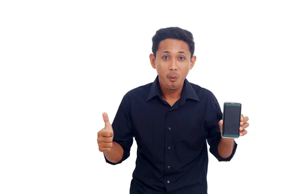 一个面带微笑的亚裔男子的画像 他举起大拇指 在屏幕上展示空白手机 — 图库照片