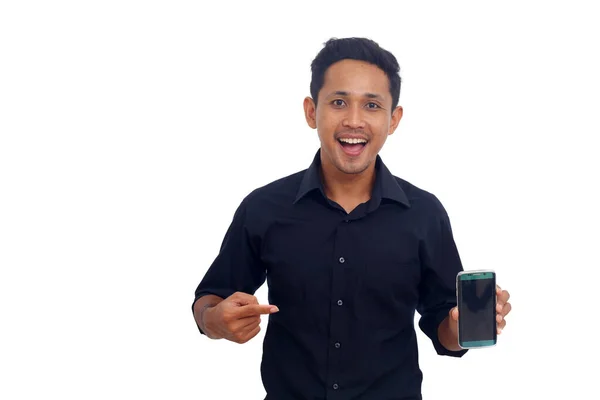 一个面带微笑的亚洲男人用手指在白色背景下的空白屏幕手机的肖像 — 图库照片
