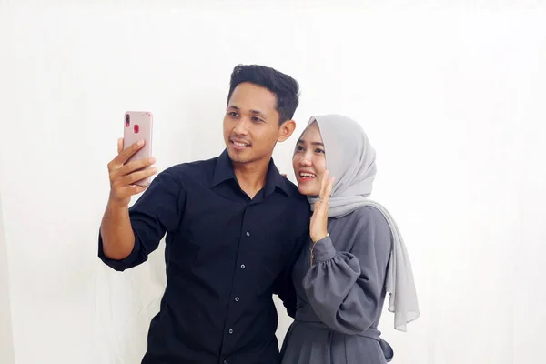 Szczęśliwa Azjatycka Muzułmańska Para Dzwoniąca Przez Telefon Komórkowy Odizolowane Biało — Zdjęcie stockowe
