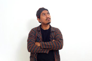 Geleneksel Java kostümlü Asyalı adam boş alana bakıyor. Beyazda izole edilmiş