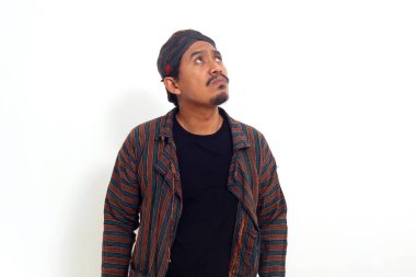 Geleneksel java kostümlü Asyalı bir adam boş uzaya bakıyor. Beyaz arkaplanda izole