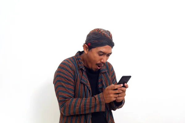 Surpreendido Asiático Homem Javanês Traje Tradicional Enquanto Segurando Telefone Celular — Fotografia de Stock