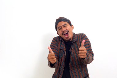 Geleneksel giysiler içinde Asyalı bir adam. Başparmağıyla işaret veriyor. İyi haberler sayesinde mutlu.