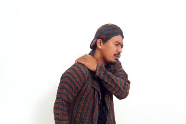 Geleneksel Java kostümlü Asyalı adam omuz ağrısı çekiyor. Beyaz arkaplanda izole