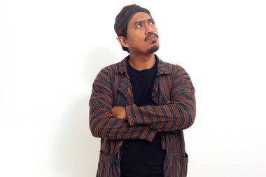 Geleneksel Java kostümlü düşünceli Asyalı adam boş alana bakıyor..