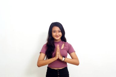 Asyalı kız kameraya bakarak ellerini sıktı. beyaz arkaplanda izole