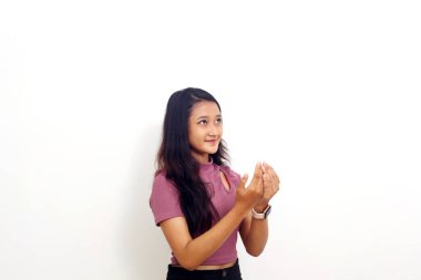 Genç Asyalı kız dua jestiyle ayakta duruyor. Beyaz arkaplanda izole