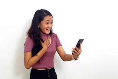 Cep telefonundan iyi haberler alırken ayakta duran Asyalı genç kız şaşırdı.