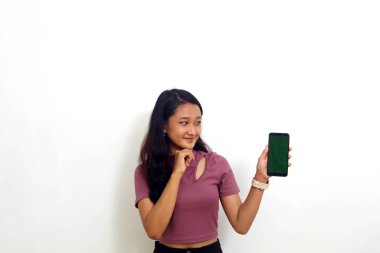 Asyalı kız mutlu bir ifadeyle cep telefonu gösteriyor. Beyaz arkaplanda izole