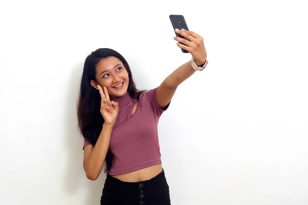 Cheerful Young Asian Girl Standing While Doing Selfie Isolated White — ストック写真