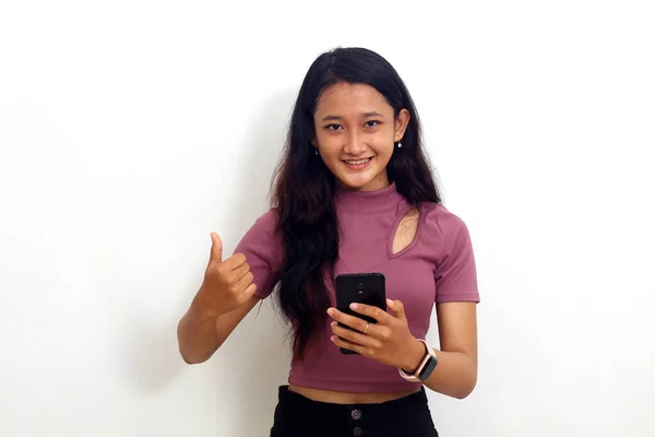 年轻女人拿着手机 用她的大拇指高举在白色的背景上 — 图库照片