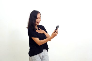 Cep telefonuna bakarken şaşırmış Asyalı genç bir kadın. Beyazda izole edilmiş