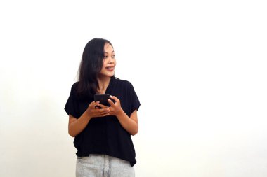 Cep telefonu tutan Asyalı genç bir kadın yan bakıyor. Beyaz arkaplanda izole