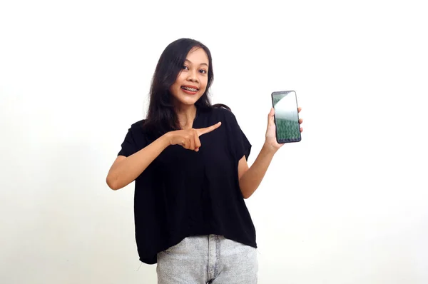 Весела Азіатська Молода Жінка Стоїть Вказуючи Мобільний Телефон Ізольовані Білому — стокове фото
