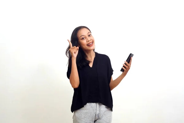 Cheerful Young Asian Woman Pointing Blank Space While Holding Cellular — Stockfoto