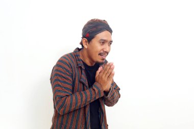 Dost canlısı Asyalı adam karşılama jestiyle ayakta duruyor. Beyazda izole edilmiş