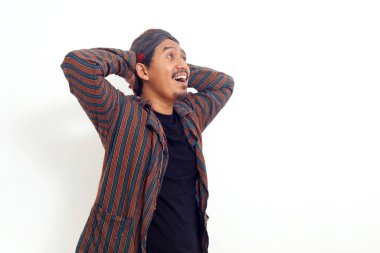 Mutlu Asyalı adam gülümseyip yukarı bakarken ayakta duruyor. Beyaz arkaplanda izole