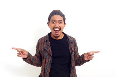 İki tarafı da işaret eden mutlu Asyalı adam ayakta duruyor. Beyaz arkaplanda izole