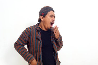 Uykulu yorgun Asyalı adam ayakta uyur, esner