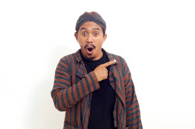 Yan tarafı göstererek ayakta duran heyecanlı Asyalı adam. Beyaz arkaplanda izole