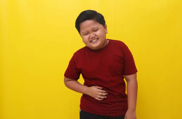 アジアの少年は胃の痛みを感じて立っている 医療の概念 黄色の背景に隔離された — ストック写真
