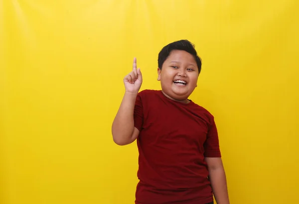 Cheerful Asian Boy Standing While Pointing Something Isolated Yellow Background — ストック写真