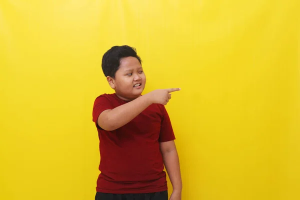 Happy Asian Boy Standing While Pointing Empty Space Isolated Yellow — Φωτογραφία Αρχείου