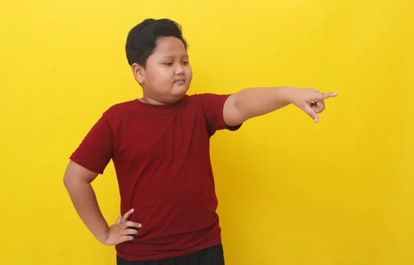 Усміхнений Азіатський Хлопчик Стоїть Вказуючи Щось Поруч Ним Ізольовані Жовтому — стокове фото