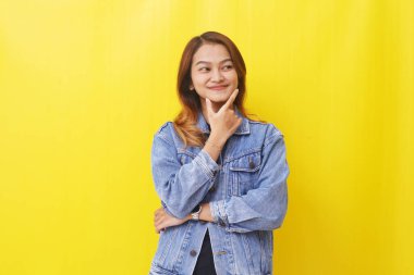 Asyalı kadın düşünceli bir ifadeyle gülümsüyor.