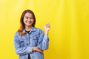 Asyalı kadın boş uzayı göstererek gülümsüyor.