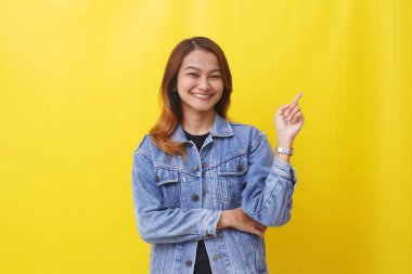 Asyalı kadın boş uzayı göstererek gülümsüyor.