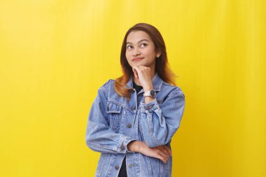 Düşünceli Asyalı kadın bir şey düşünürken ayakta duruyor.