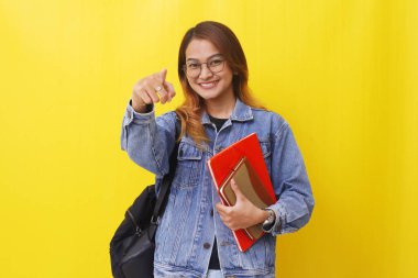 Elinde kamerayla dikilen Asyalı genç bir öğrencinin portresi..