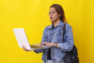 Dizüstü bilgisayarında haber okurken Asyalı bir üniversite öğrencisinin ayakta durmasına şaşırdım. Sarıda izole edilmiş.