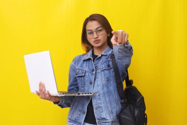 Elinde dizüstü bilgisayarla kamerayı gösteren Asyalı üniversite öğrencisinin portresi..