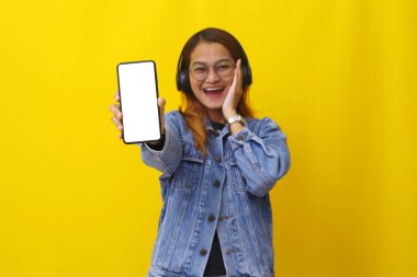 Boş bir cep telefonu ekranı gösteren mutlu Asyalı kadın. Cep telefonuna seçici odaklanma