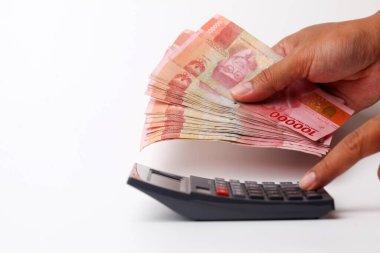 Banknotları tutarken hesap makinesi kullanmak. Kopyalama alanı ile beyaz arkaplanda izole