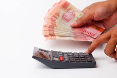 Banknotları tutarken hesap makinesi kullanmak. Kopyalama alanı ile beyaz arkaplanda izole