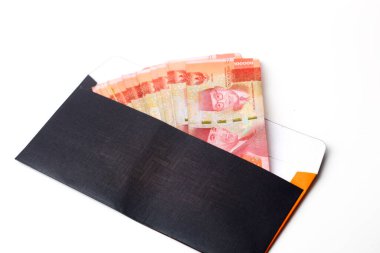 Zarfın içinde Endonezya parası var. Beyaz arkaplanda izole