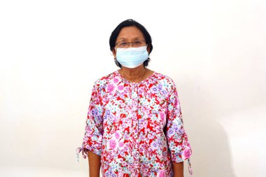 Senior elderly woman standing and wearing face mask. Isolated on white background