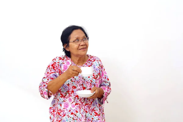 Ανώτερη Ασιάτισσα Στέκεται Κρατώντας Ένα Φλιτζάνι Καφέ Και Κοιτάζοντας Κενό — Φωτογραφία Αρχείου