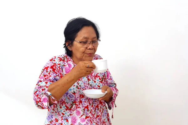 Elderly Asian Woman Holding Cup Hot Tea Blowing Isolated White — ストック写真